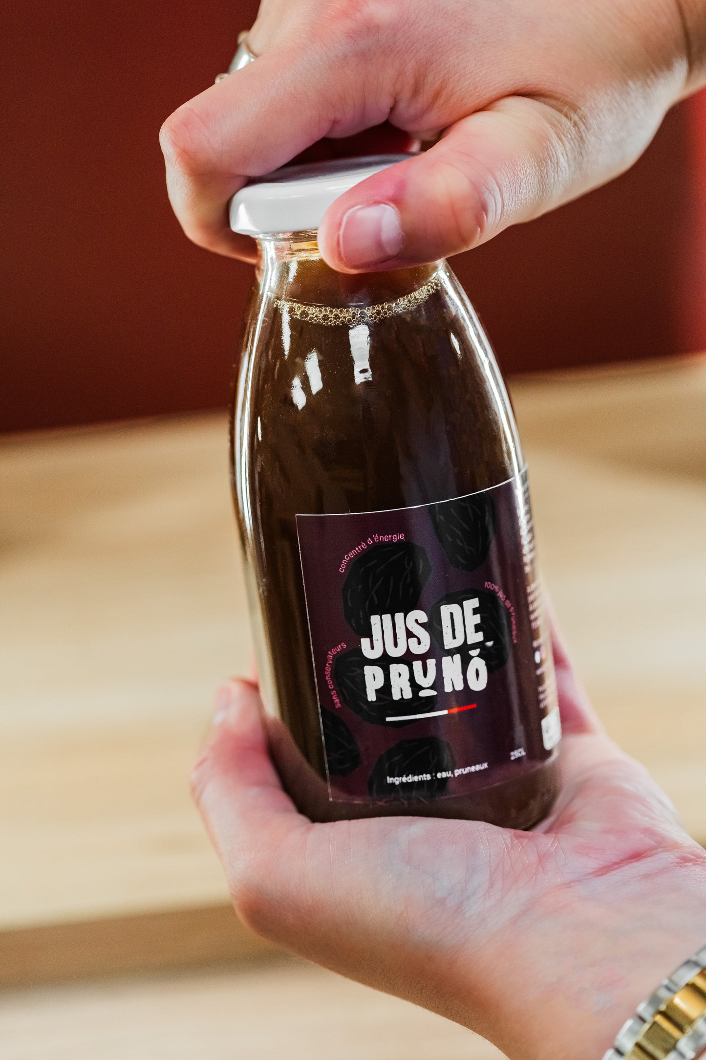 bouteille de jus de pruneaux en verre en train d'etre ouverte